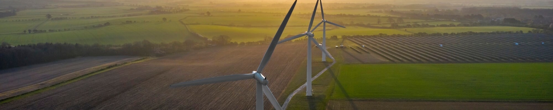 image of wind turbines and solar panels in English countryside taken from above 